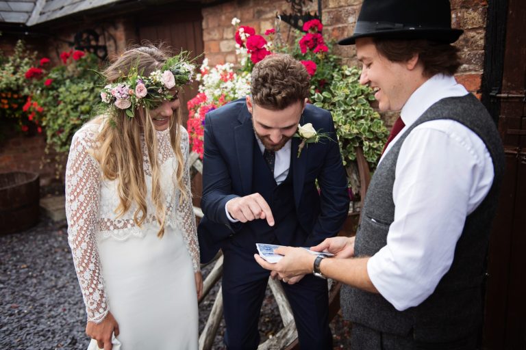 Magician Darren Campbell doing his magic trick to bride and groom at Overbarn, Gloucester.