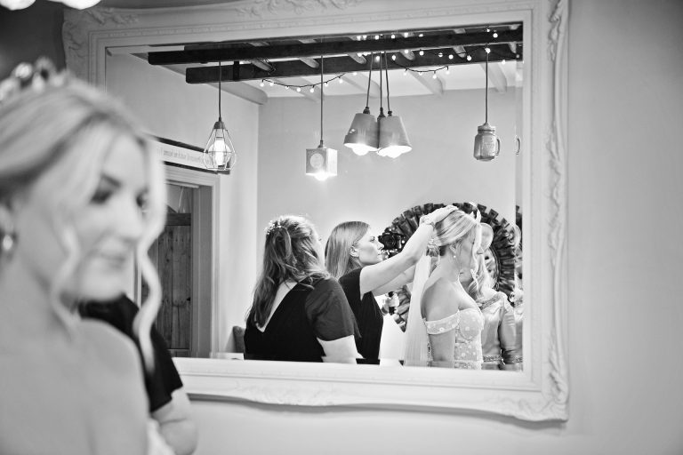 Bride having her veil fitted - view point from a reflection in the mirror in the bridal suite at Blackwell Grange.