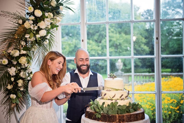 Photo of bride and groom cutting their wedding cake at Margam