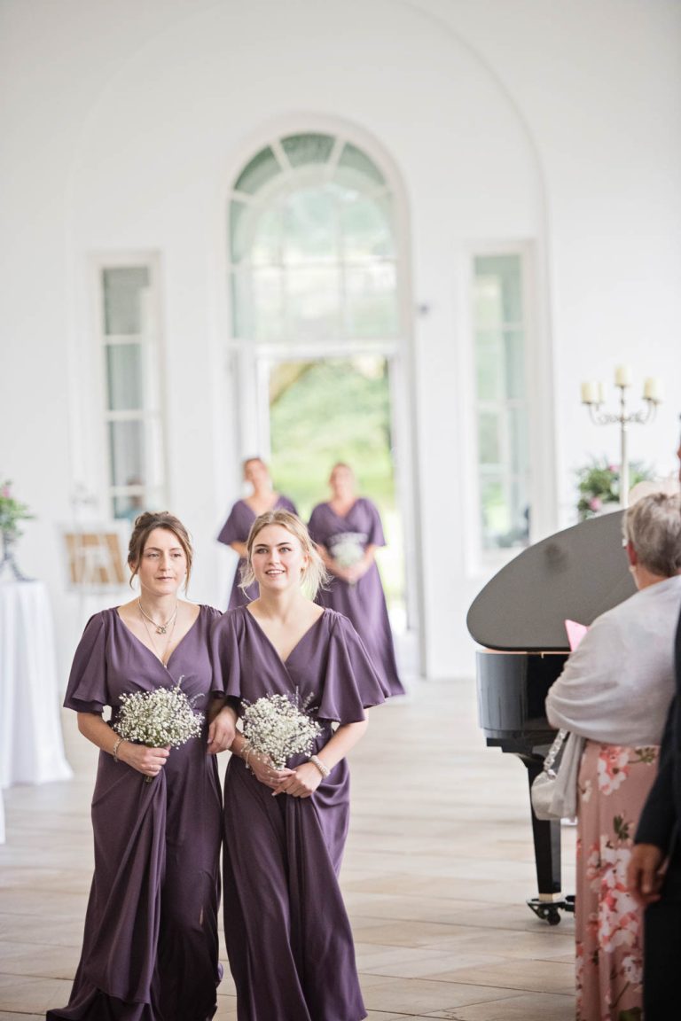 Elegant portrait photo of bridesmaids walking down the wedding isle at Margam Country Park.