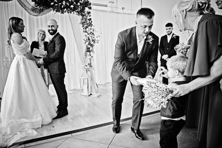 Black & white photo of a ring boy exchanging the rings.