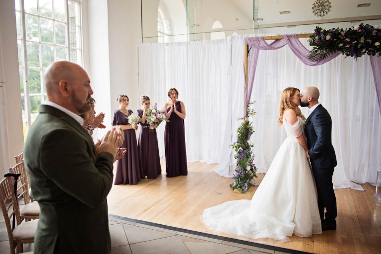 Natural photo of bride and groom kissing after being announced husband and wife.