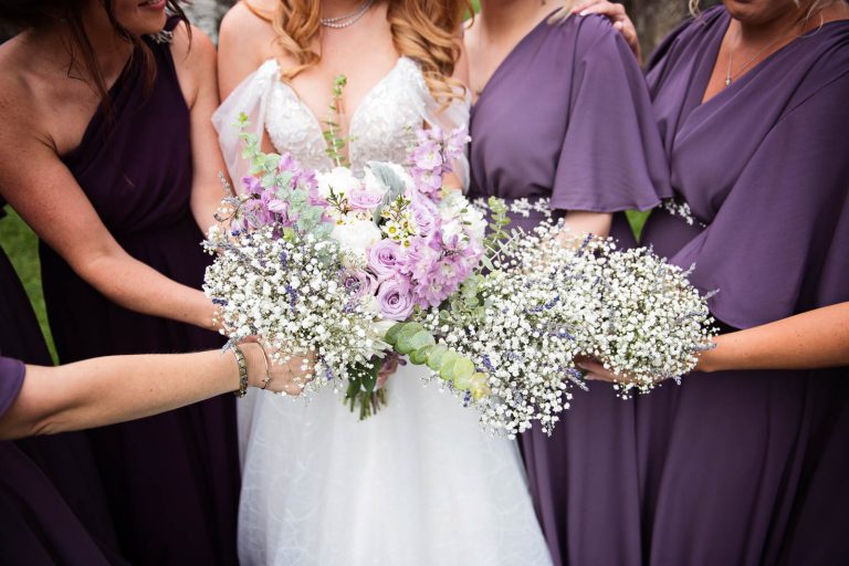 Bride and bridesmaids hold the wedding bouquets in one big bunch. Colourful.