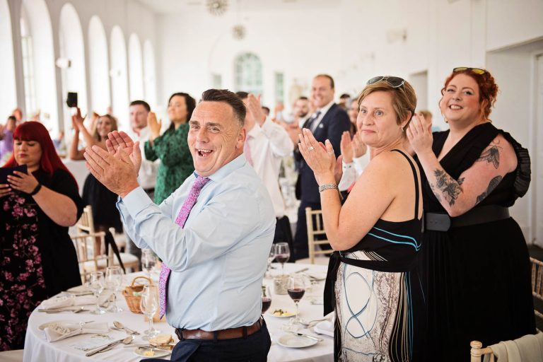Natural image taken of friends cheering as the bride and groom enter the wedding breakfast at Margam.