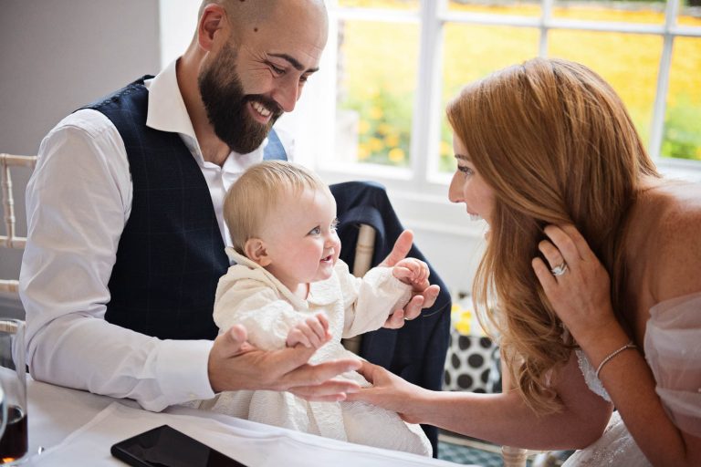 Natural image of bride and groom with baby.