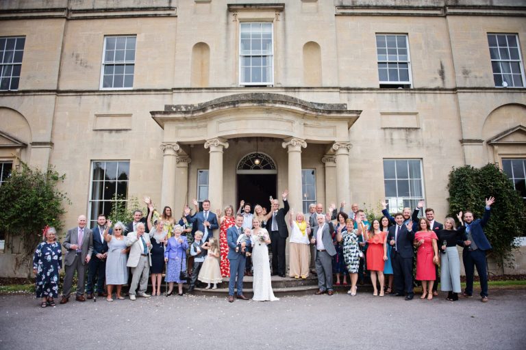 Small wedding party on the steps cheering last minute wedding deals.