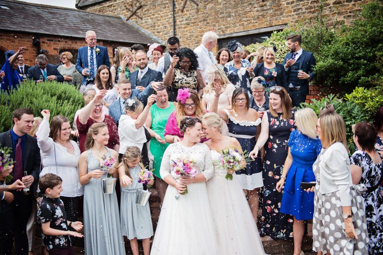 Bride and bride celebrate with their guests with confetti at Dodmoor House.