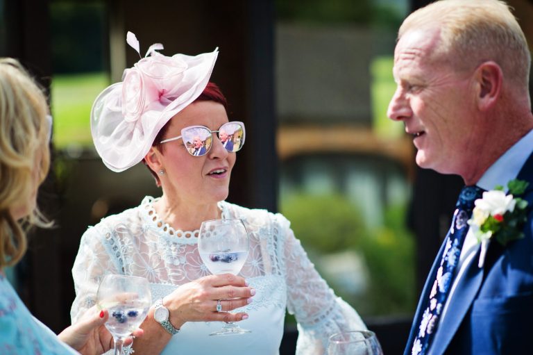 Candid photograph of wedding guests chatting