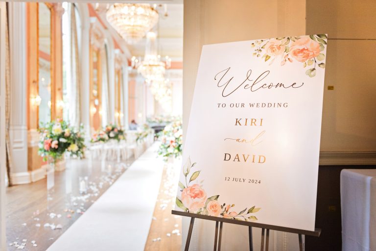 Elegant ceremony room in Danesfield House Hotel & Spa with welcome sign board welcoming guests to the wedding of Kiri & David.