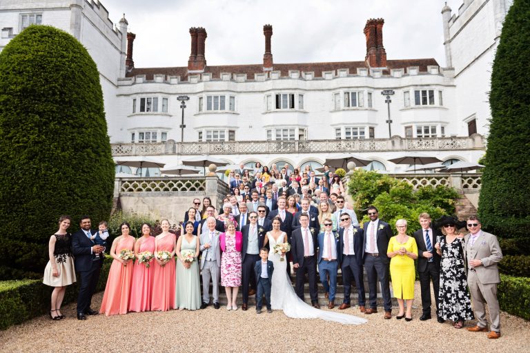 A formal group shot of everyone at the wedding on the steps of Danesfield House Hotel and Spa. Photography by Ben Roberts, Blooming Photography.