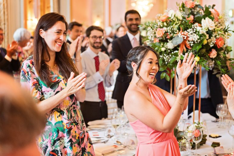 Guests clapping in a natural photo taken as the bride and groom (not seen in picture) enter Danesfield House Ballroom.