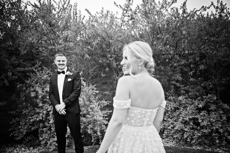 B&W image of groom looking fondly towards his bride. Candid photo by Blooming Photography. Taken at Blackwell Grange, Warwickshire.