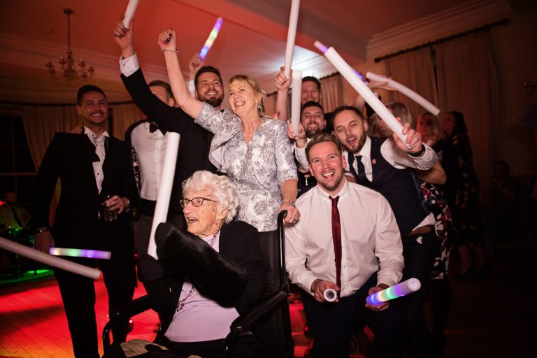 Fun family photo of people dancing on the dance floor with gran, taken at a wedding at Eastington Park.