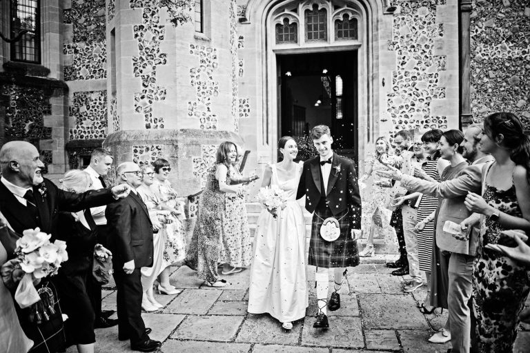 Bride and groom leaving showered by confetti (black and white photo), Winchester Registry Office, Photo by Blooming Photography