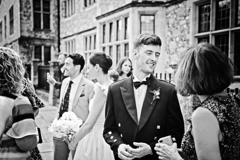 Natural wedding moments captured candidly, groom chatting to guests, photo by Blooming Photography