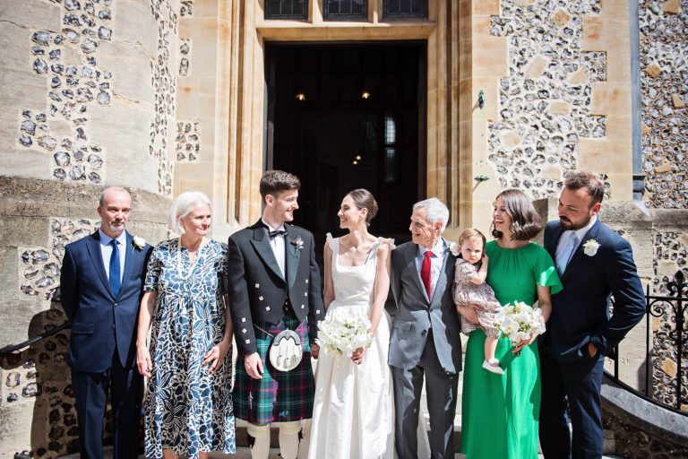 Relaxed group photo outside Winchester Registry office wedding. Photo by Blooming Photography