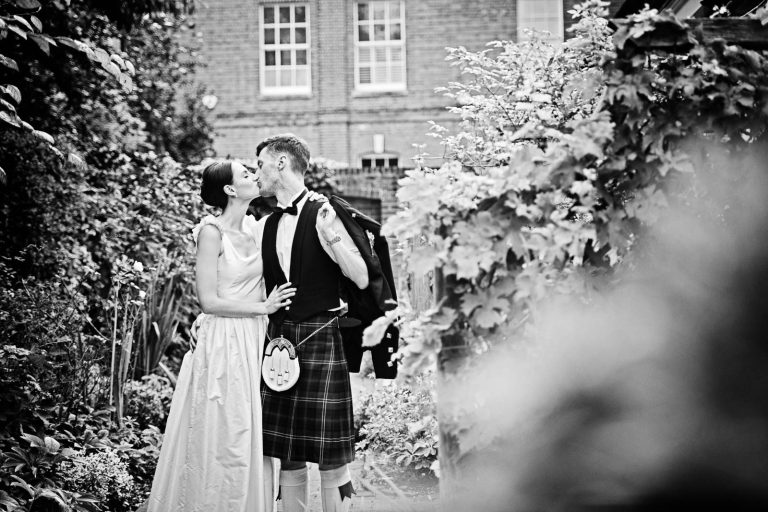 Storytelling wedding photo of bride and groom kissing whilst at Hotel Du Vin Winchester, Black & white photo by Blooming Photography