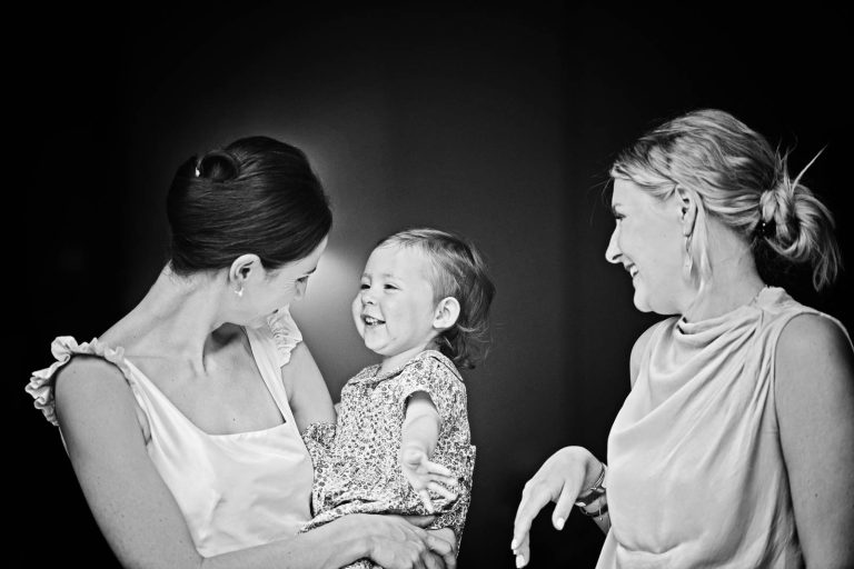 Bride with flower girl laughing with another guest, black and white photograph taken at Hotel du Vin, Winchester by Blooming Photography
