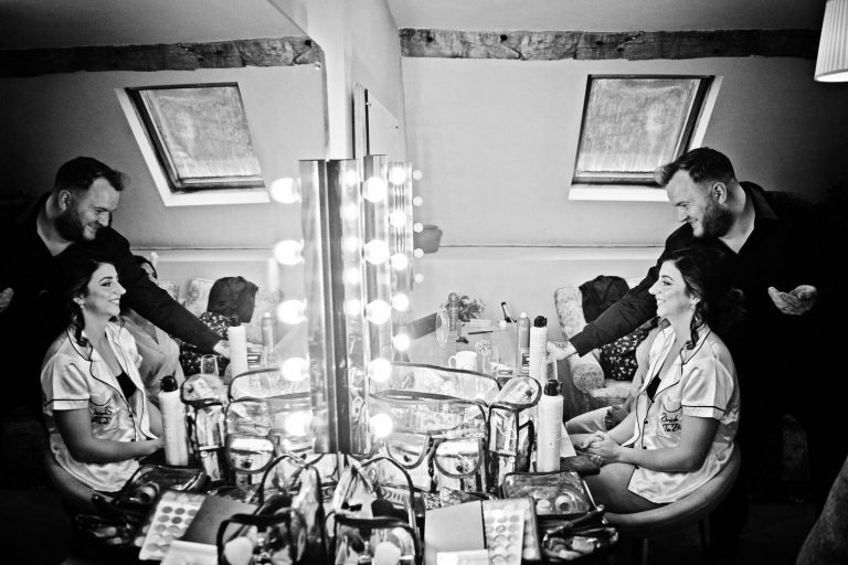 B&W candid image of the bride getting her hair done.