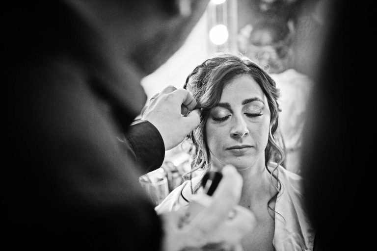 B&W candid image of the bride getting her hair done.