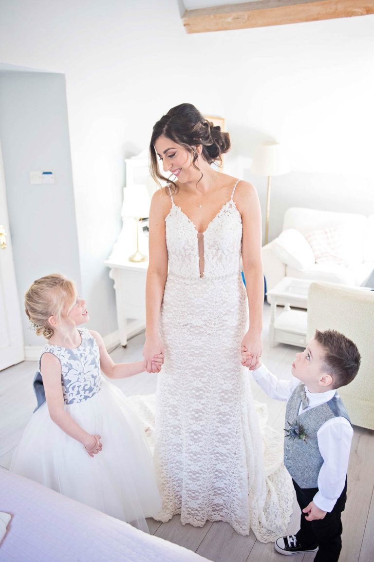 Bride holding the flower girl and page boys hand.