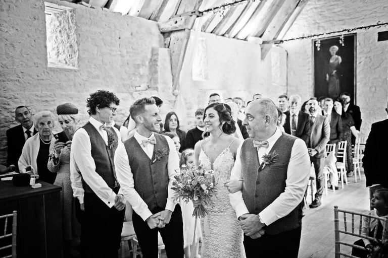 B&W candid photo of bride walking down the isle at Owlpen Manor.