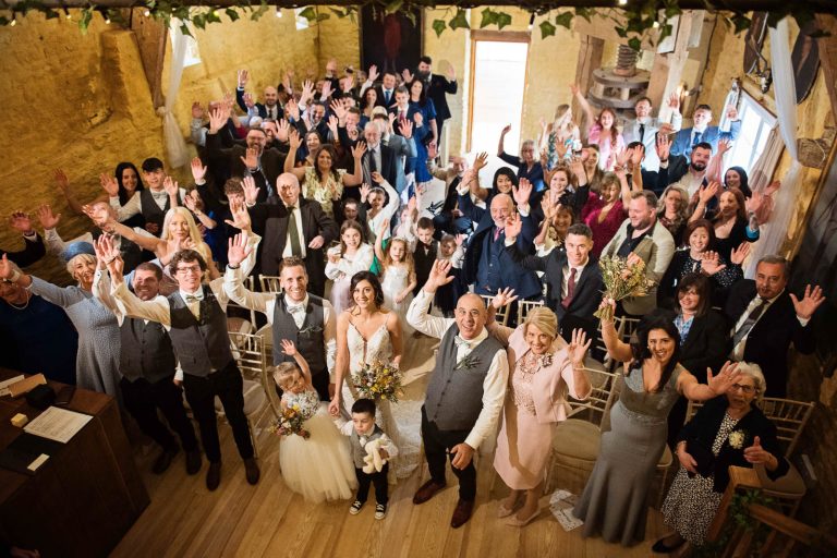 Large group shot of wedding guests inside at Owlpen Manor.