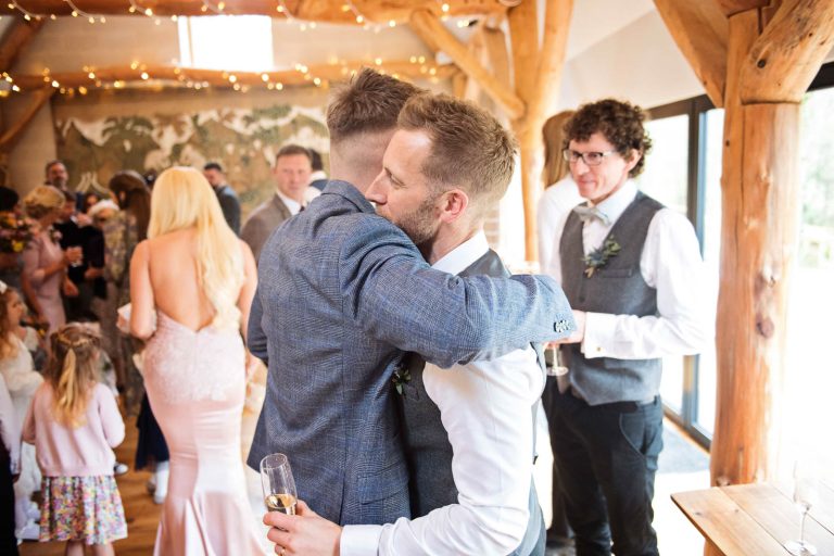 Candid photo of groom getting hugged at Owlpen Manor.