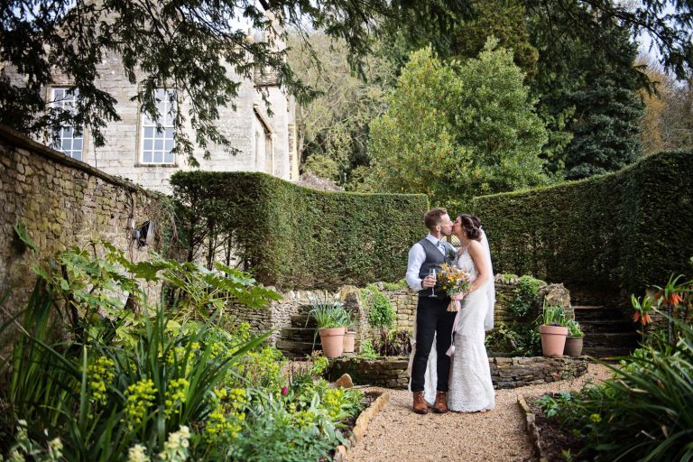 Photo of the bride and groom kissing in the grounds at Owlpen Manor.