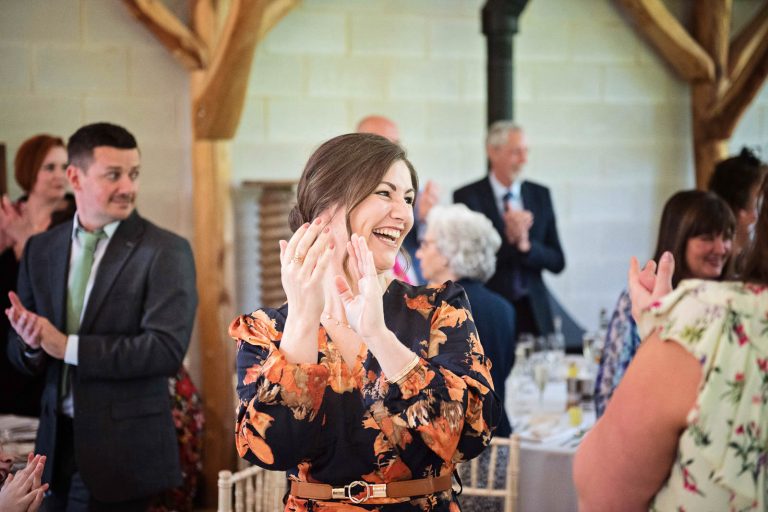 Candid photo of wedding guests clapping.