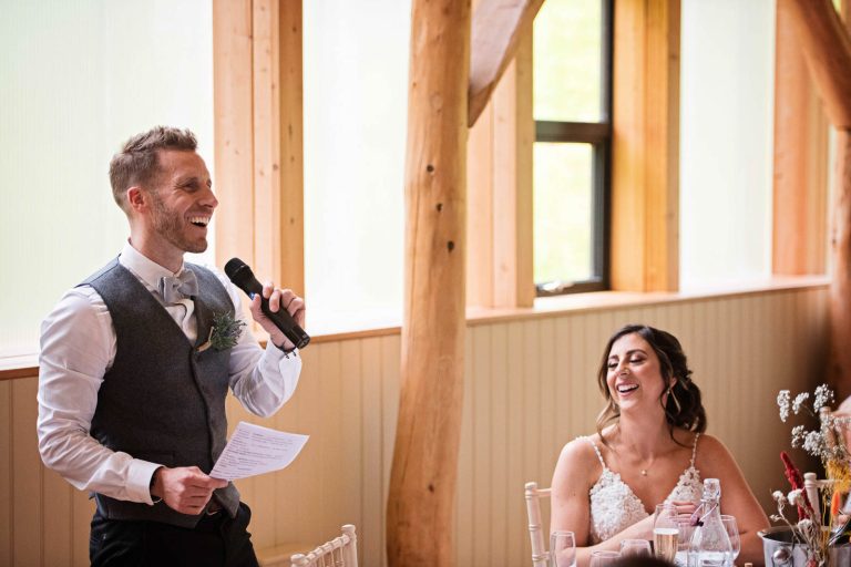 Candid photo of groom delivering his wedding speeches at Owlpen Manor