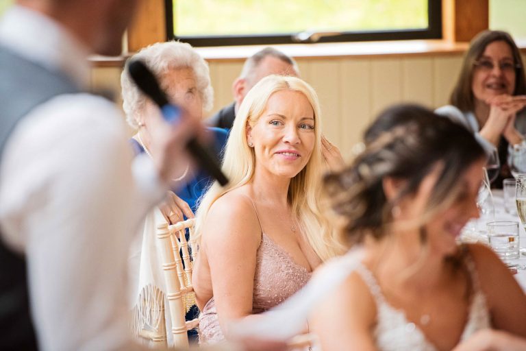 Candid photo of a wedding guest smiling.