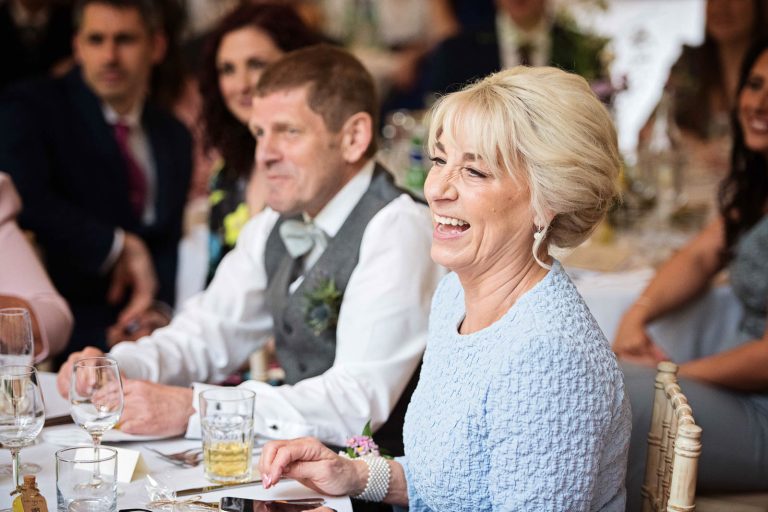 Mother of the groom laughing at the speeches.