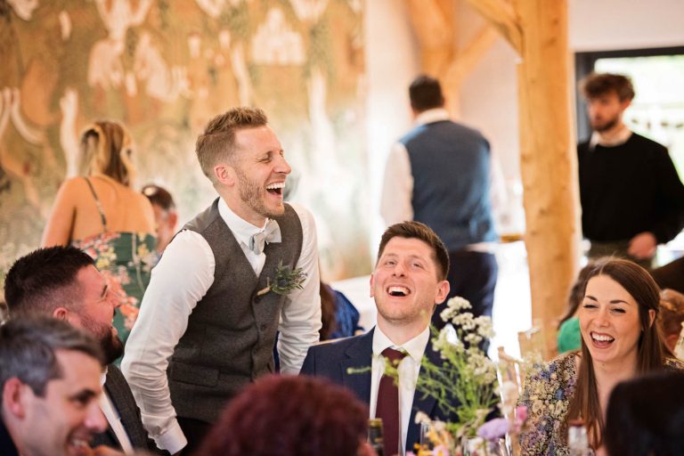 Groom laughing with his wedding guests.