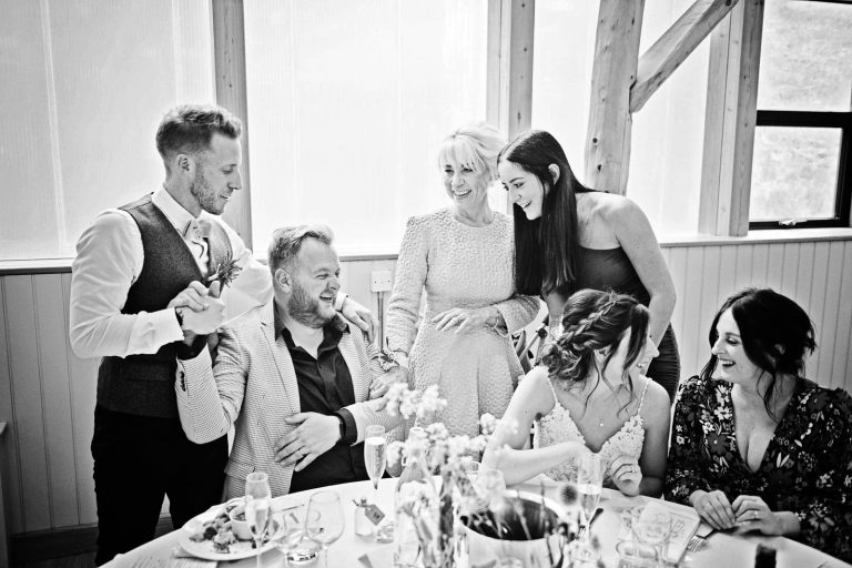 Storytelling image of wedding guests chatting and laughing together.