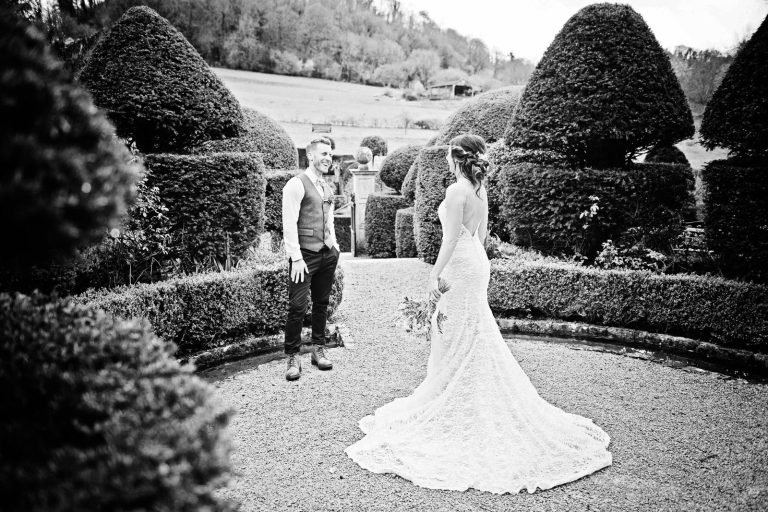Photo of bride and groom in the gardens at Owlpen Manor. B&W