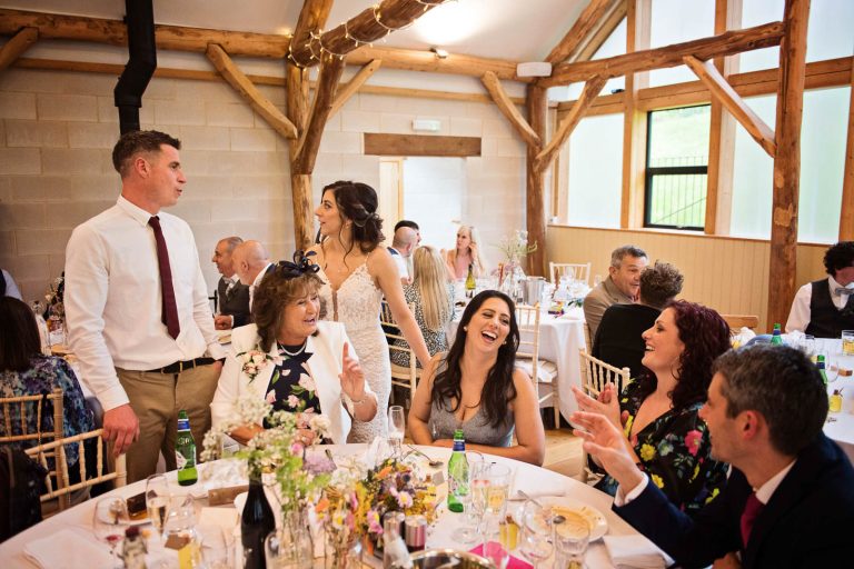 Candid photo of wedding guests chatting during the wedding speeches.