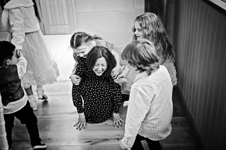 Candid photo of parent getting attacked by children.