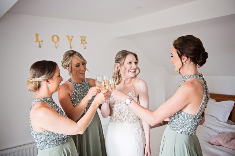 Bride and bridesmaids "cheers" each other for getting ready on time.