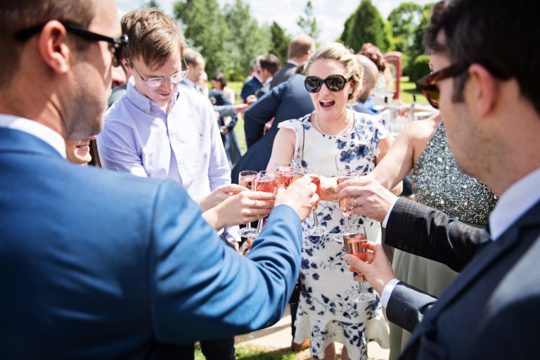 Documentary style wedding photography of guests chatting and laughing with the bride.