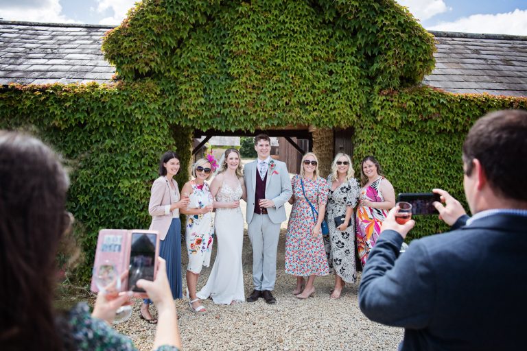 Bride and groom pose with their friends for a photo.