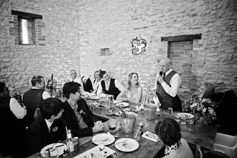 B&W Documentary style wedding photo of father of the bride delivering his speech.