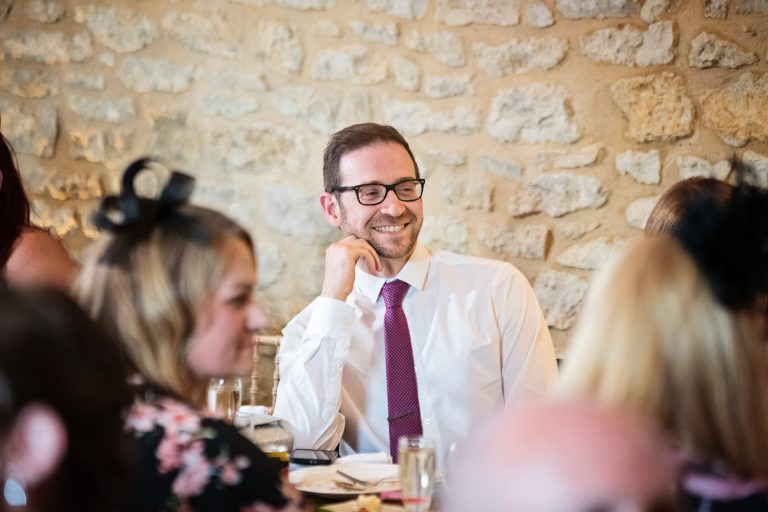 Storytelling photo of guest laughing at wedding speech.