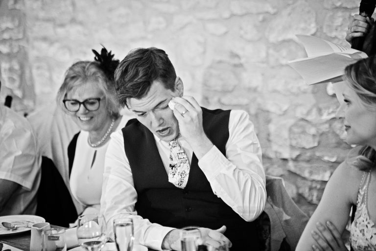 Groom wiping tears from his eye during the wedding speech.