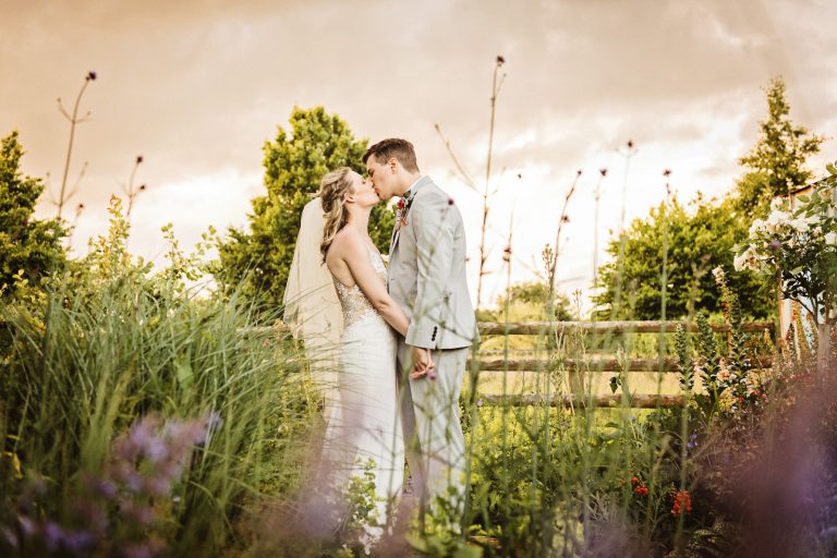 Bride and groom kiss in the gardens.