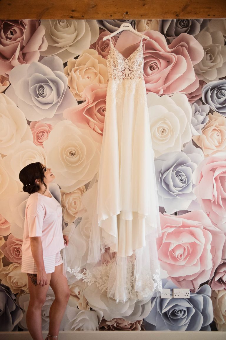 Brides wedding dress hung up at Kingscote Barn