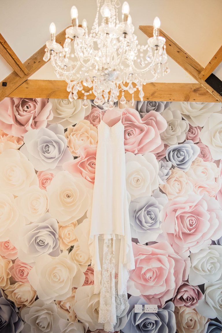 Brides wedding dress hung up at Kingscote Barn, Gloucestershire