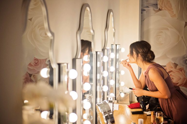 Mirror shot of bridesmaid getting ready at Kingscote Barn