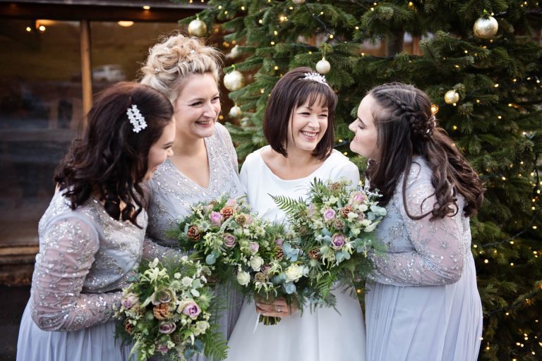 Bride and bride laughing at wedding at Kingscote Barn, Gloucestershire.