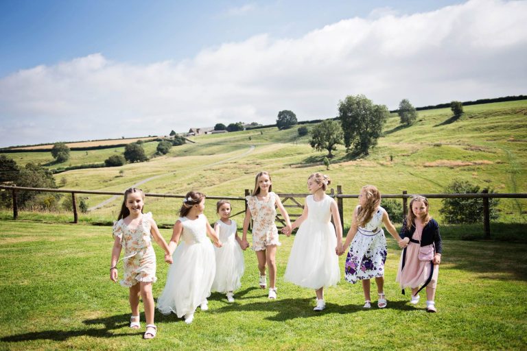 Candid photo of kids holding hands at Kingscote Barn wedding.